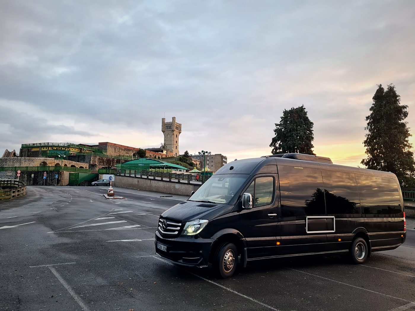 Minibús VIP negro de Kapital Bus en una explanada al atardecer